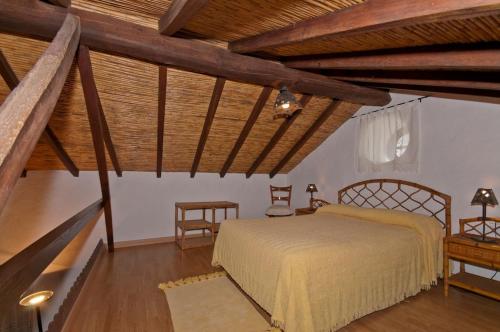 特罗尔库瓦斯莫雷纳酒店的一间带一张床的卧室,位于带木制天花板的房间内