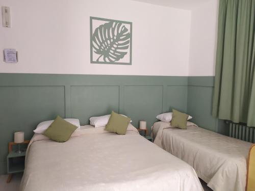 Francavilla in SinniAlbergo Mango的绿窗帘间内的两张床