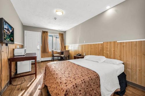 多伦多公园汽车旅馆的酒店客房设有一张大床和一张书桌。