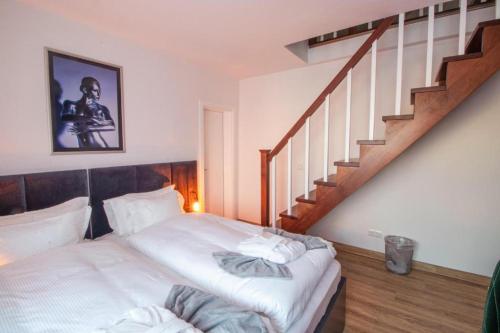贝尔吉施格拉德巴赫Hotel Dona的一间卧室设有一张床和一个楼梯