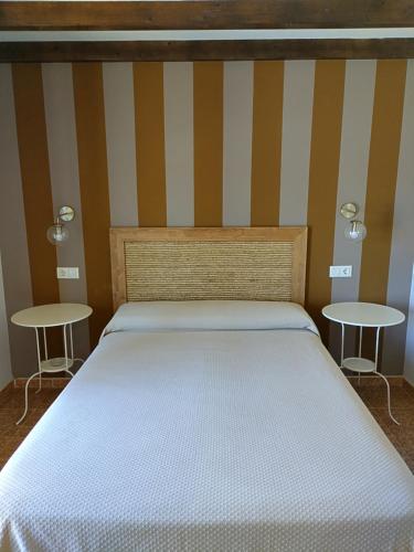 卡斯特罗波尔Hostal Restaurante Parajes的卧室配有白色的床和2张桌子