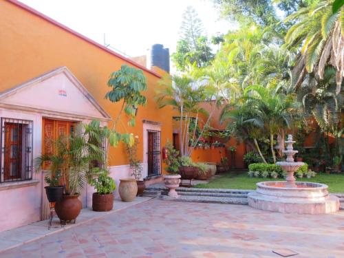 瓜达拉哈拉Casa Rosa Amelia的一座橙色的建筑,庭院里设有喷泉