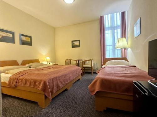 维也纳Self Check-in Hotel Am Schottenpoint的酒店客房设有两张床和一张桌子。