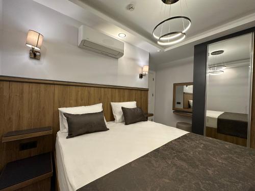 安塔利亚Quality Gold Suite Hotel的一间卧室配有一张大床和镜子