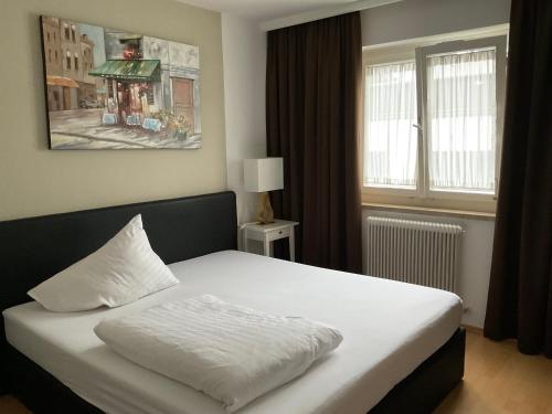 塞基兴Hotel Berg的卧室配有白色的床和窗户