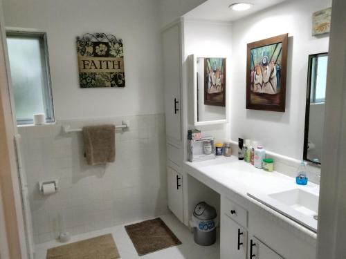 休斯顿The Art Abbey Bed & Breakfast的白色的浴室设有水槽和镜子