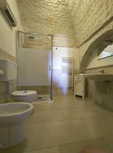 阿尔贝罗贝洛迪比科度假酒店的带淋浴、卫生间和盥洗盆的浴室