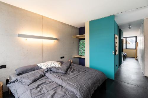 贡德尔芬根FRIZ Art的一间卧室设有一张床和蓝色的墙壁