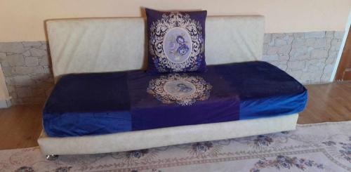Bordj LutaudMimi cheriti的床上有蓝色和白色的被子
