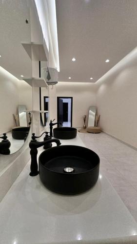 哈伊勒منتجعات رغيد الفندقية的浴室设有黑色水槽和3个水槽。