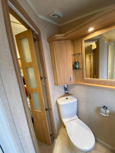 桑当Red Squirrel Lodge的一间带卫生间和镜子的小浴室