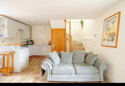 马姆斯伯里Stans Place Self Catering Cottage的带沙发的客厅和厨房