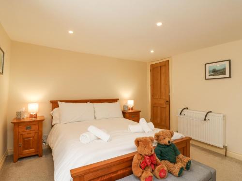 波特兰Bowman's Cottage的卧室里床边的两只泰迪熊
