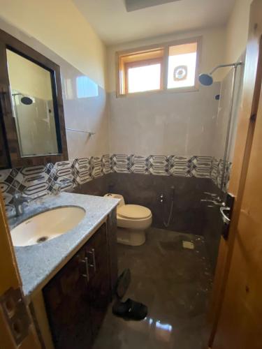 罕萨Home of golden oriole的一间带水槽、卫生间和镜子的浴室