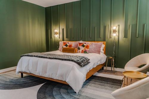 路易斯威尔Groovy Condo in the Vibrant NuLu District的一间卧室设有一张带绿色墙壁的大床