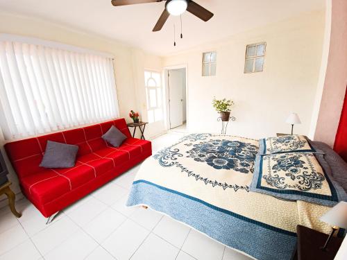 瓜达拉哈拉Esquina del Pintor的卧室内的红色沙发,配有床