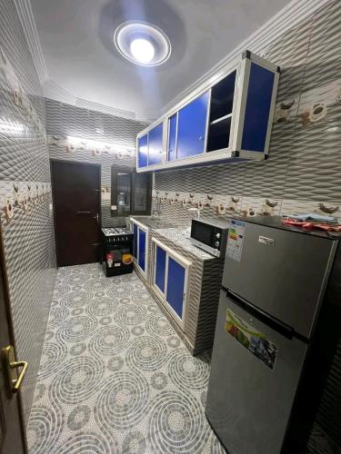 瓦加杜古As résidence meubles E p的厨房配有蓝色橱柜和冰箱。