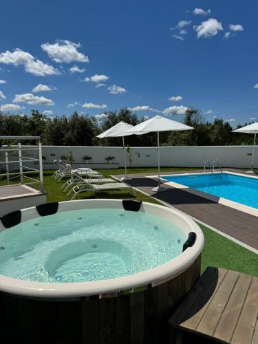 São Pedro de AlvaJasmine Hotel的游泳池旁的庭院里设有一个按摩浴缸