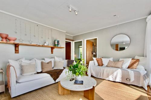 旺阿雷Kereru Cottage - Matapouri Holiday Home的客厅配有白色的沙发和桌子