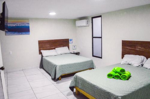马萨特兰Posada Vacacional Brisas del Mar的一间设有两张带绿鞋的床的房间