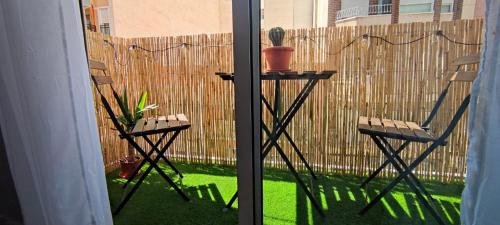 埃尔切Apartamento en el centro de Elche con terraza的庭院设有两把椅子、一张桌子和围栏