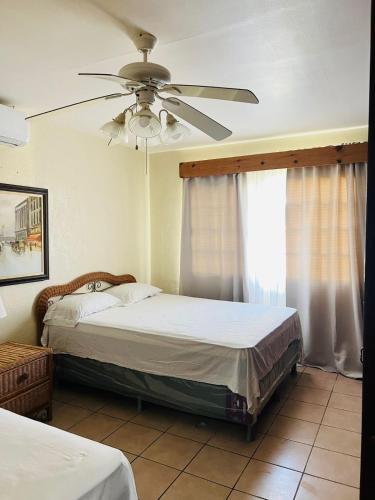 拉塞瓦villa en palma real的一间卧室配有两张床和吊扇