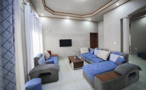 基加利OMX Hotel Remera的客厅配有蓝色的沙发和电视
