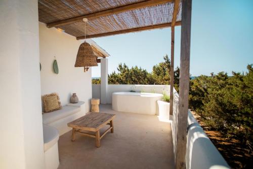 米乔尔海滩Estel Formentera的带浴缸、桌子和长凳的浴室