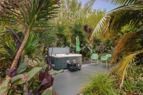 陶朗加Swiss-Kiwi Retreat A Self-contained Appartment or a Tiny House option的花园内带2把椅子和1张书桌的庭院