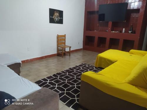 大坎普Hostel Pantanal Experience - Pantanal n' Bonito Tours的客厅设有黄色沙发和电视