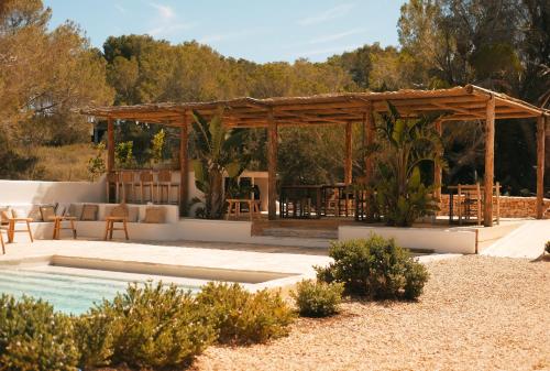 米乔尔海滩Estel Formentera的一个带桌椅的凉亭和一个游泳池