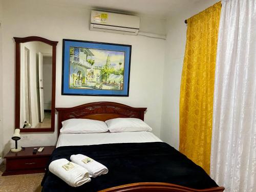 卡塔赫纳Habitación Cerca de aeropuerto的一间卧室配有一张床,上面有两条毛巾