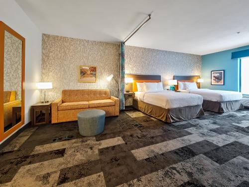 波林布鲁克Home2 Suites By Hilton Bolingbrook Chicago的酒店客房,设有两张床和一张沙发
