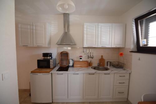 奥赫里德Apartment Bojadzi的厨房配有白色橱柜和水槽