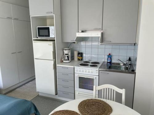 拉彭兰塔Toimiva huoneisto kahdelle! Smart TV, Saimaanranta, nopea netti!的厨房配有白色橱柜和白色炉灶烤箱。