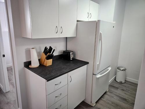 博普雷Le 4 Saisons 4的厨房配有白色橱柜和冰箱。
