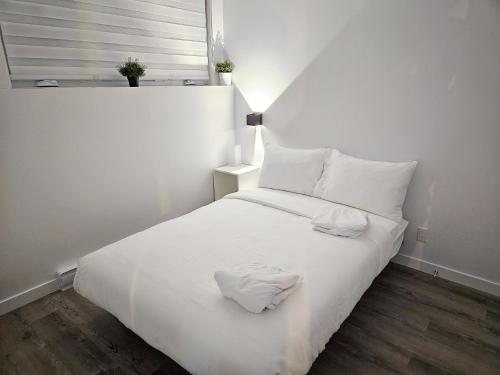 博普雷Le 4 Saisons 4的一张白色的床,上面有两条白色毛巾
