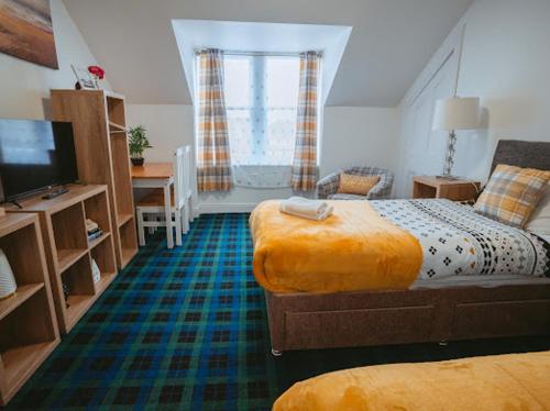 奈恩Nairn View Guest House的一间卧室配有两张床、一张桌子和一台电视。