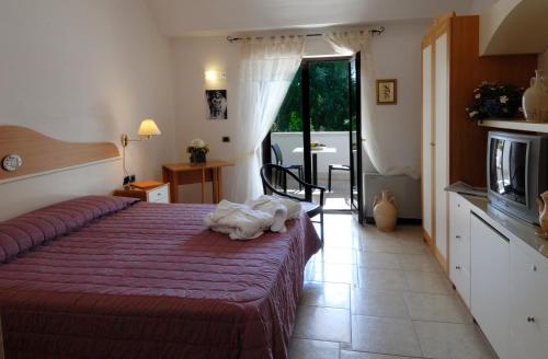 马丁纳弗兰卡玛西丽雅基安科奈托里切拉酒店的一间卧室配有一张红色床罩的床