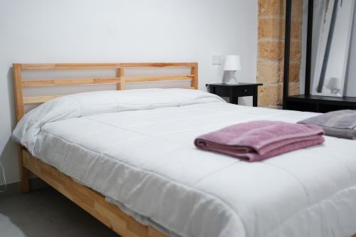 科佩尔蒂诺Beb la casa di tino的一张白色大床,上面有粉红色的毛巾