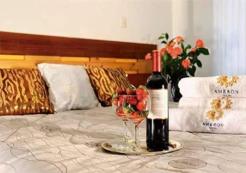 胡利亚卡Hostal Ameron的床上的一瓶葡萄酒和一杯葡萄酒