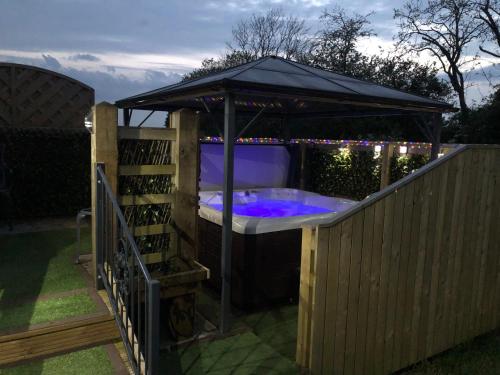 LincolnshireSpacious Lodge With Hot Tub的围栏上的凉亭内的热水浴池
