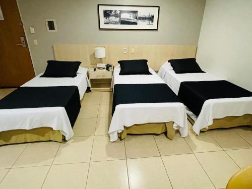 戈亚尼亚麦阿尼酒店的酒店客房设有三张床和一张桌子