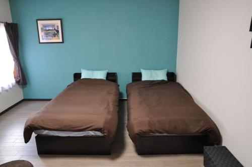 长滨市Minpaku KEN HOUSE - Vacation STAY 60980v的两张睡床彼此相邻,位于一个房间里