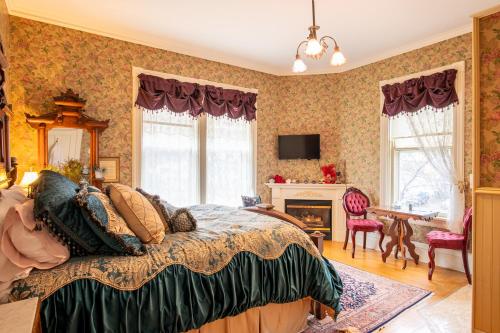 斯蒂尔沃特Aurora Staples Inn的一间卧室配有一张床、一张桌子和一个壁炉