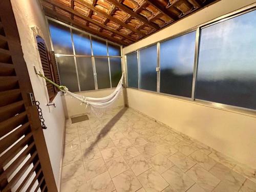 大伊瓜巴La casa magica - A casa mágica的带窗户的客房内设有带吊床的阳台