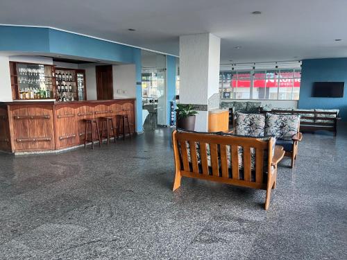 瓜拉派瑞Hotel Quatro Estações的大楼内带长凳和酒吧的大堂