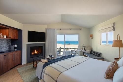 滨海城圣地海滩度假酒店的一间卧室设有一张大床和一个壁炉