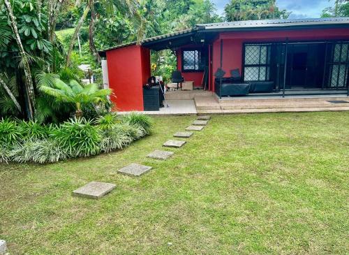 苏瓦Breath of Fresh air Suva Fiji的一座红色的房子,前面有一个石头堆成的院子