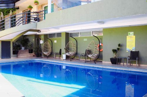 库埃纳瓦卡Hotel Borda Cuernavaca的一座带椅子的游泳池以及一座建筑